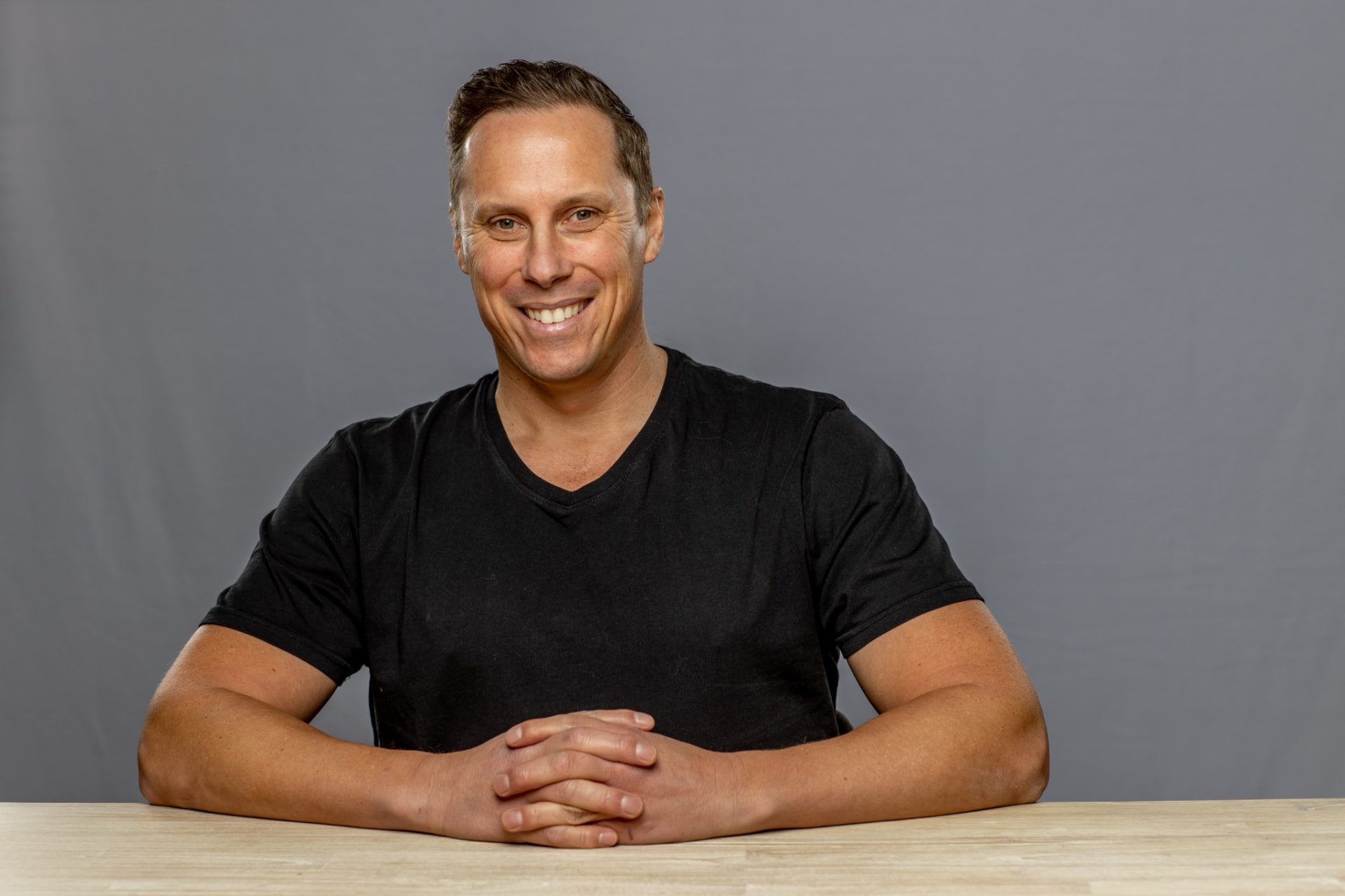 Black shirt, seated at desk